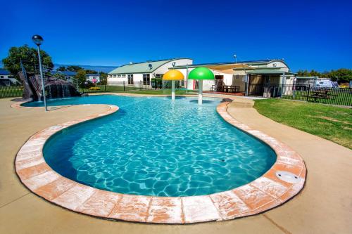 a swimming pool in a yard with a house at NRMA Warrnambool Riverside Holiday Park in Warrnambool