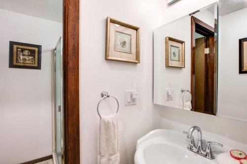 ein weißes Badezimmer mit Waschbecken und Spiegel in der Unterkunft Snowater Condo #31 - Fireplace - Wifi - Sleeps 4 in Glacier