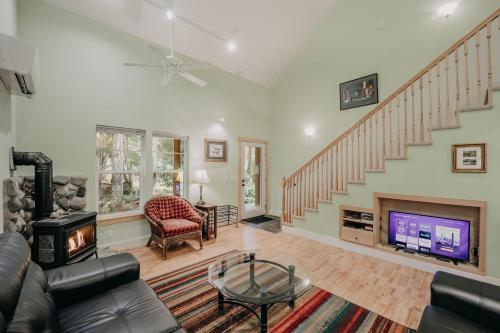 a living room with a fireplace and a staircase at Glacier Springs Cabin 12 - Wi-Fi - A-C - Evc in Glacier