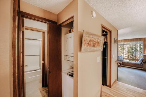 eine kleine Küche mit einem Kühlschrank und einem Fenster in der Unterkunft Snowater Condo #41 - Wi-Fi - Sauna - Soaker Tub in Glacier