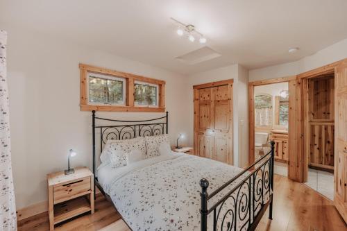 Schlafzimmer mit einem schwarzen Bett und Holzböden in der Unterkunft Snowline Cabin #34 - Hot Tub - Wi-Fi - Ping Pong in Deming