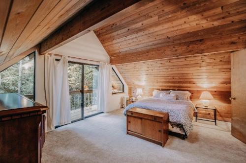 ein Schlafzimmer mit einem Bett und einer Holzwand in der Unterkunft Snowline Cabin #43 - Hot Tub - Pets Ok - Wifi in Glacier