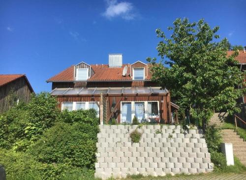 a house with a brick wall in front of it at Ferienhaus Tine am Schlossberg in Zandt in Zandt