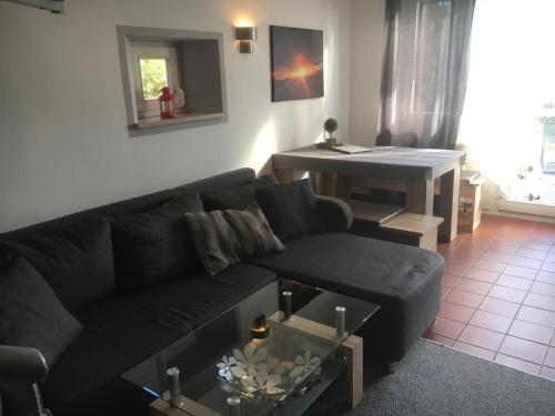 a living room with a black couch and a table at Ferienhaus Tine am Schlossberg in Zandt in Zandt