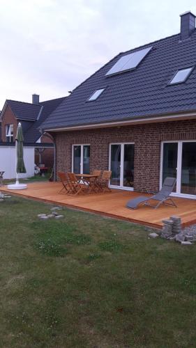 ein Haus mit einer Terrasse mit Stühlen und einem Dach in der Unterkunft Ferienhaus Mau in Meeschendorf