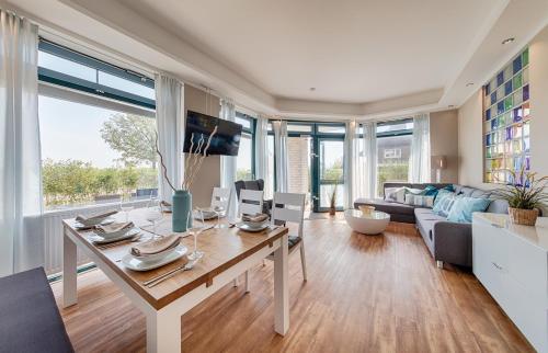 a living room with a table and a couch at Strandburg Aquamarin in Burgtiefe auf Fehmarn 