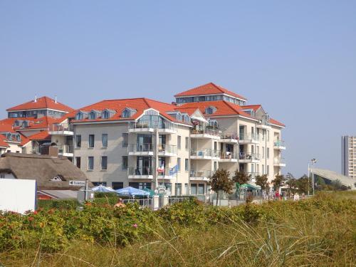a large building with red roofs on a beach at Strandburg Aquamarin in Burgtiefe auf Fehmarn 