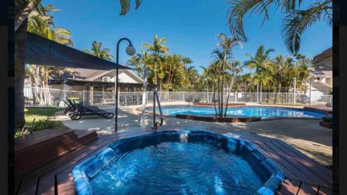 a large swimming pool in a yard next to a house at Waterfront 3 Bedroom House in Family Friendly Resort in Gold Coast