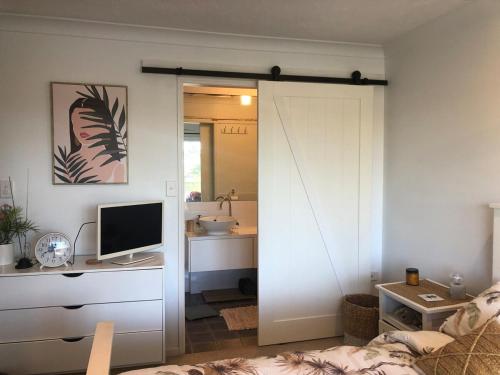 1 dormitorio con puerta corredera que conduce a un baño en Waterfront 3 Bedroom House in Family Friendly Resort, en Gold Coast