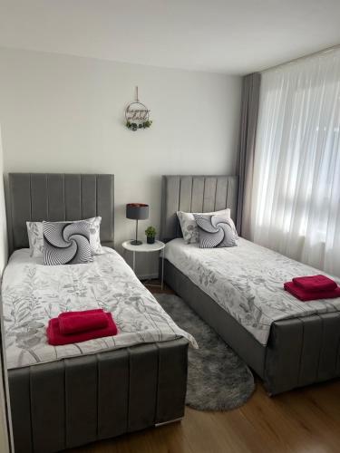 a bedroom with two beds with red pillows at Spacious rooms for rent 10 min from Tower Bridge in London