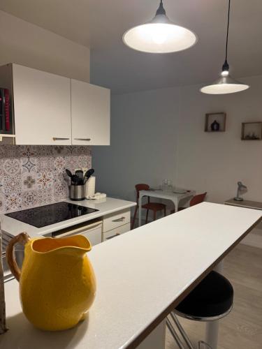 une cuisine avec un vase jaune assis sur un comptoir dans l'établissement Studio 2 bords de Loire, à Orléans