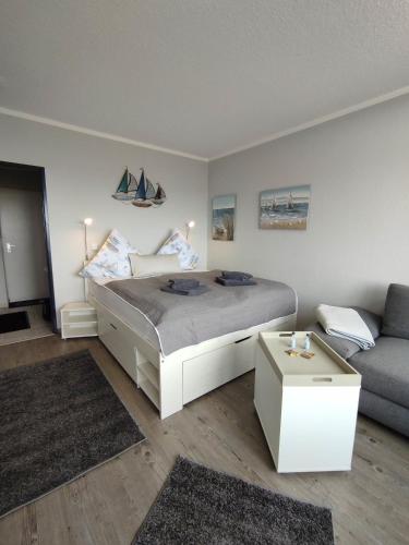 a bedroom with a bed and a couch at FeWo Eggers 1 in Burgtiefe auf Fehmarn 