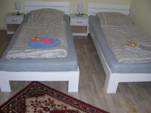 two beds sitting on top of a wooden floor at Kleine FEWO zentral gelegen in Künzell