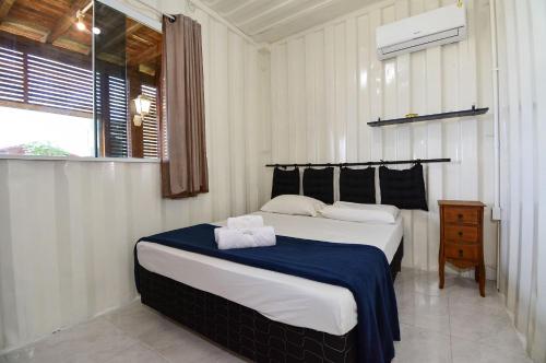 a bedroom with a large bed with a blue blanket at Contêiner Exclusivo - Praia da Gamboa - GAR002 in Gamboa