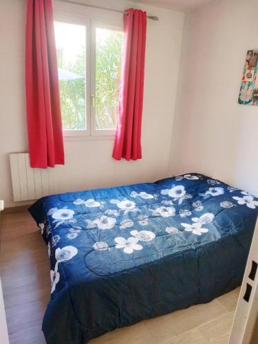 Ce lit se trouve dans une chambre dotée de rideaux rouges et d'une fenêtre. dans l'établissement Le Lagon Bleu - Fidji 12 - Rez de jardin privatif - Tennis - Piscine, à Fréjus