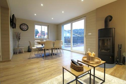 un salon avec une table et une cheminée dans l'établissement Gite, Maison Chaleureuse, à Saint-Léonard