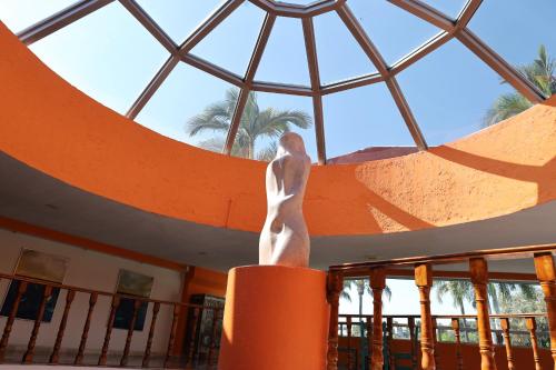 a statue of a man on an orange pole in front of a window at Hotel Aristos Cuernavaca in Cuernavaca