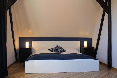 Schlafzimmer mit einem Bett mit einem schwarzen und weißen Kopfteil in der Unterkunft Bauernhof Höpner "Im Backhaus" in Vadersdorf