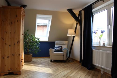 ein Wohnzimmer mit einem Stuhl und einem Fenster in der Unterkunft Bauernhof Höpner "Im Backhaus" in Vadersdorf