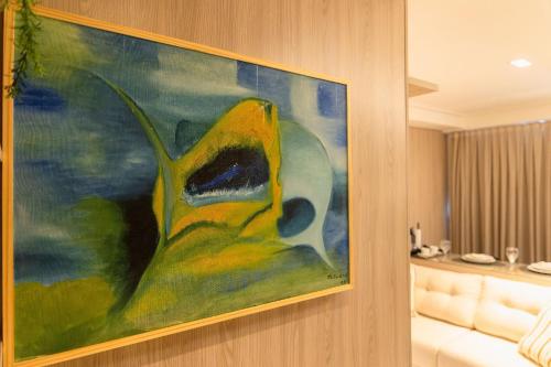 a painting hanging on a wall in a room at Move #914 - Apartamento Confortável by Carpediem in Tambaú