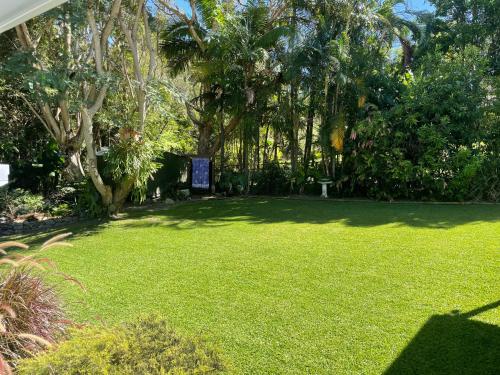 un patio con césped verde y árboles y un cartel en Bella Valla, en Valla Beach