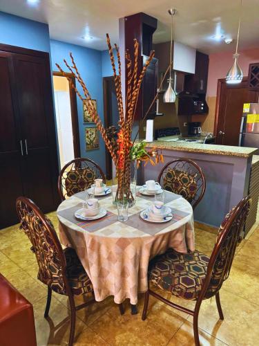 a dining room table with chairs and a vase on it at Apartamentos Casa Del Valle in San Pedro Sula