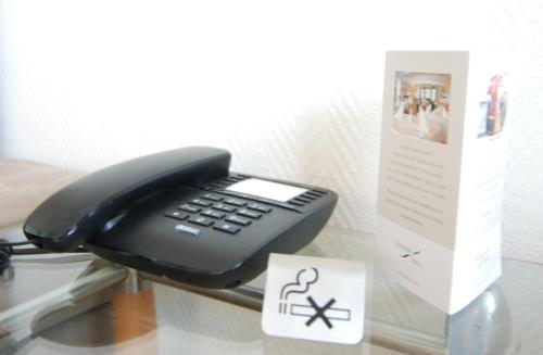 een zwarte telefoon op een tafel naast een doos bij STRANDIDYLL, 58 - Typ A1S in Grömitz