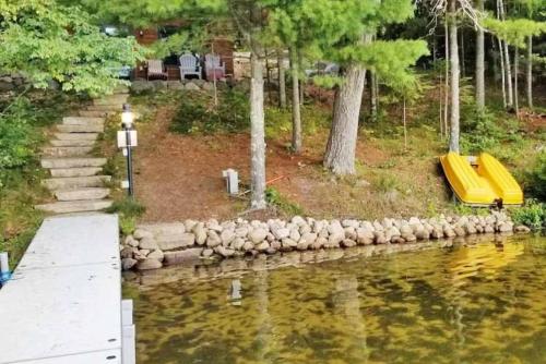 a yellow slide on the side of a body of water at The Cedar Lakehouse in Lake Tomahawk WI in Lake Tomahawk