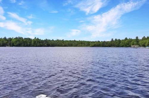 a large body of water with trees in the background at The Cedar Lakehouse in Lake Tomahawk WI in Lake Tomahawk