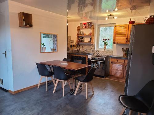 une cuisine avec une table et des chaises en bois dans l'établissement Maison avec Jardin en bord de rivière, à Fresnay-sur-Sarthe
