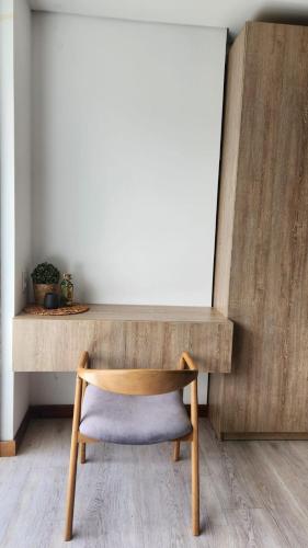 a chair sitting in front of a wooden desk at Campestre Apartment Loft in El Retiro