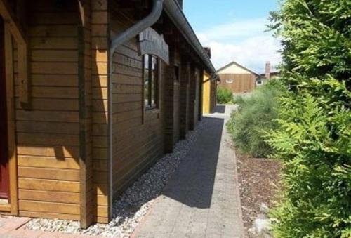 a side of a building with a sidewalk next to it at Ferienhaus Bliev-Hee Nr 1 in Klink
