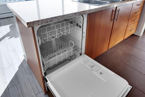 a dishwasher with its door open in a kitchen at Stylish 2BD Condo in Downtown with Marina View in Vancouver