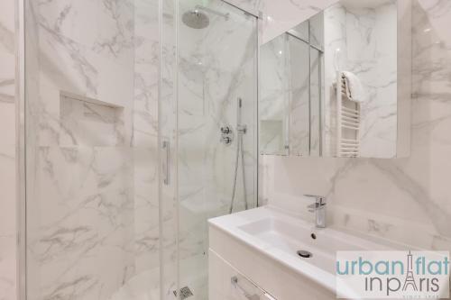 une salle de bain blanche avec une douche et un lavabo dans l'établissement 61- Big Luxury Parisian Flat 2DD, à Paris