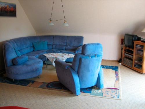 Una sala de estar con un sofá azul y una mesa. en Haifisch, en Großenbrode-Kai