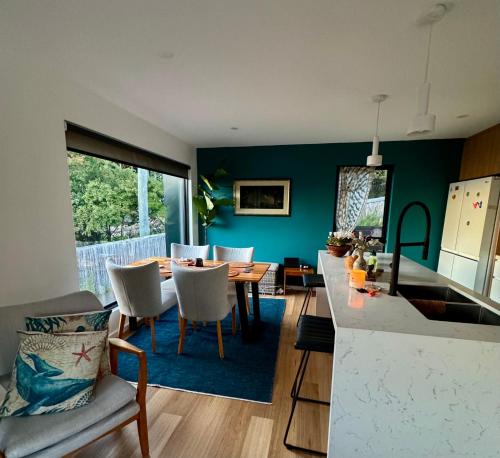 a kitchen and dining room with a table and chairs at Fabulous, New, Well Appointed Beach House in Kingston Beach