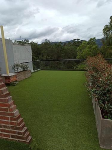 a backyard with green grass and a volleyball court at Campestre Apartment Loft in El Retiro
