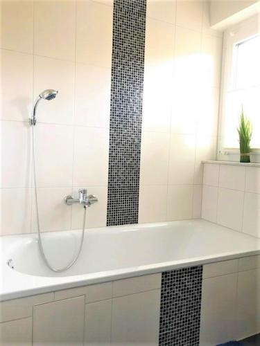 a white bathroom with a shower and a tub at Frau Holle in Wolfhagen