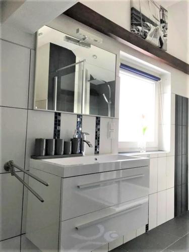 a white kitchen with a sink and a mirror at Frau Holle in Wolfhagen