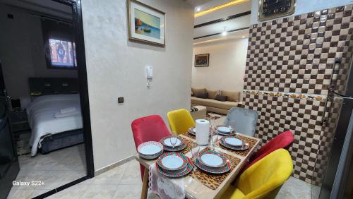 a room with a table with chairs and a dining room at Appartement 7 min de l'aéroport de Marrakech in Marrakech
