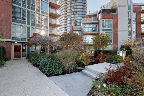a garden in front of a tall building at Stylish 2BD Condo in Downtown with Marina View in Vancouver