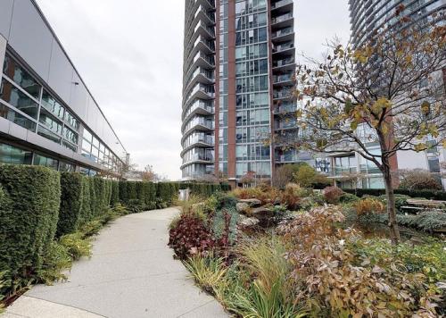 a walkway in front of a tall building at Stylish 2BD Condo in Downtown with Marina View in Vancouver