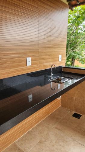 a kitchen counter with a sink and a window at Chalés Sitío dos Ventos in Lavras Novas