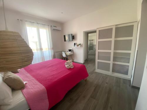 a bedroom with a pink bed with a teddy bear on it at La Piccola Formica Charme Rooms in Palermo