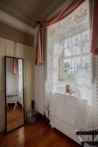 a room with a window and a white curtain at Casa da Ponte de Mucela in Vila Nova de Poiares