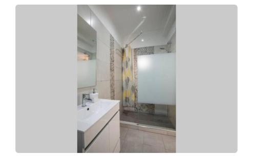 a white bathroom with a sink and a shower at BeGuest Casetta Cleo in Páteo