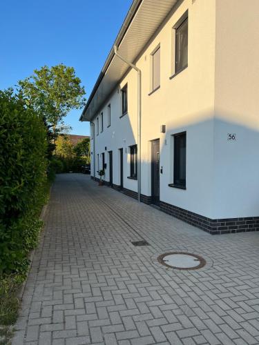 a cobblestone street next to a white building at Ferienwohnung 2404 App 6 in Burhave in Burhave