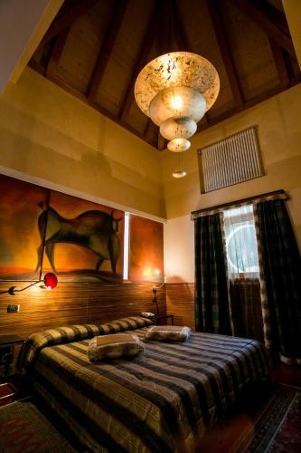 a bedroom with a bed and a chandelier at Design Oberosler Hotel in Madonna di Campiglio