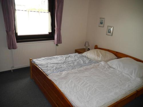 a bed in a bedroom with a window at Bungalow M 07 in Burhave in Burhave