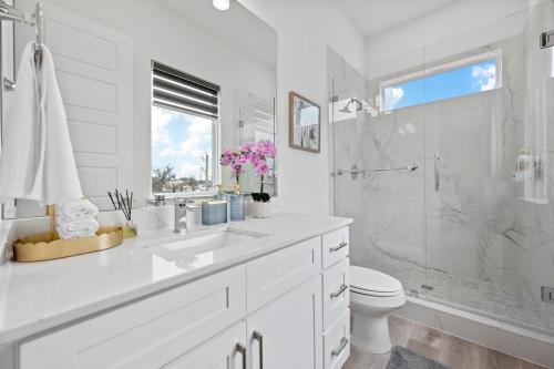a white bathroom with a sink and a shower at Pet-Friendly l Brand New Space l Downtown in Dallas